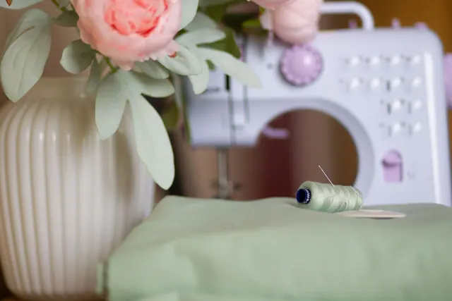 Chic sewing setup with a vintage machine, flowers, and thread.